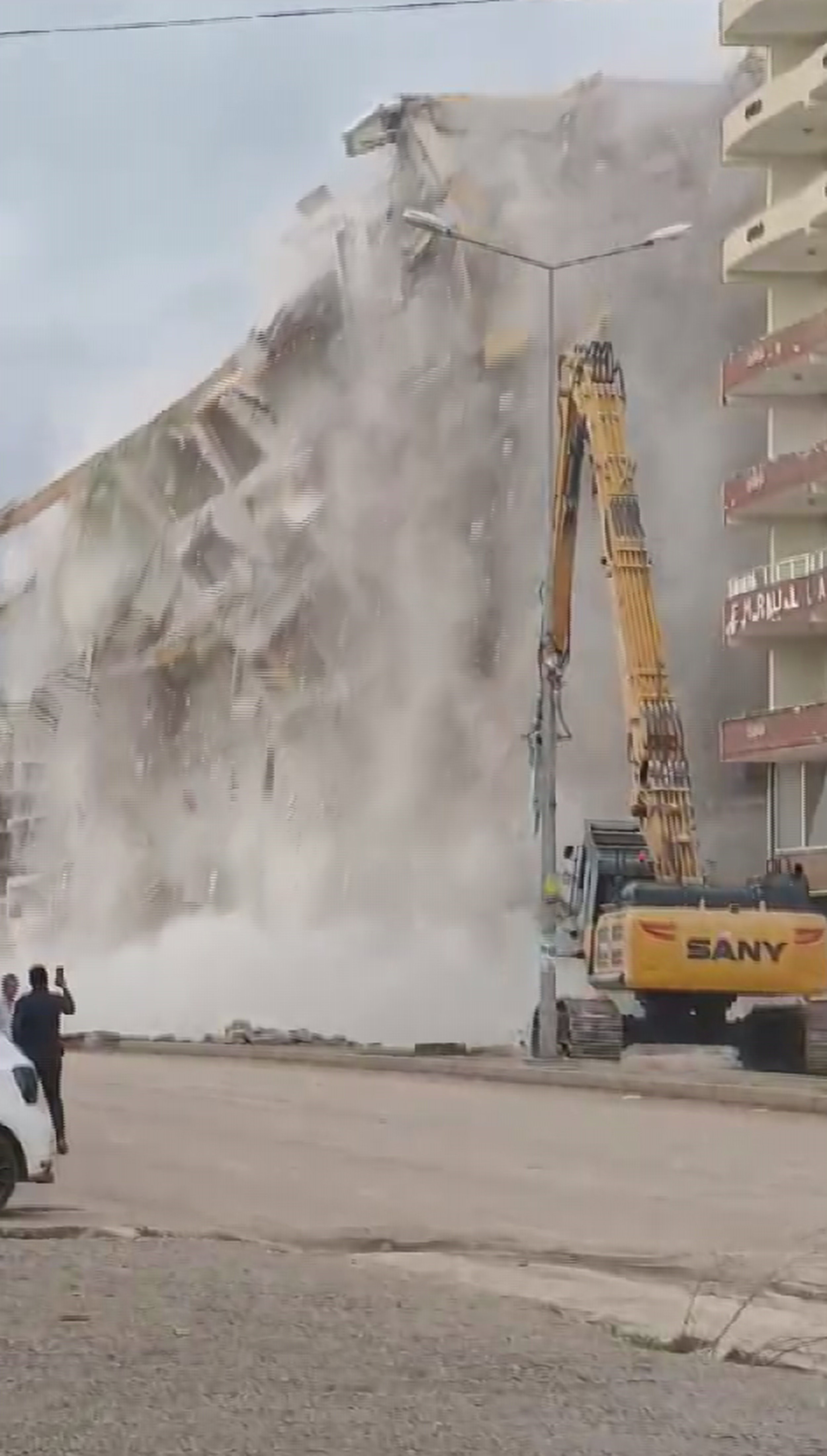 Hatay'ın Hassa ilçesinde 10 katlı bir binanın yıkım anında meraklı vatandaşların panik anları kaydedildi. 