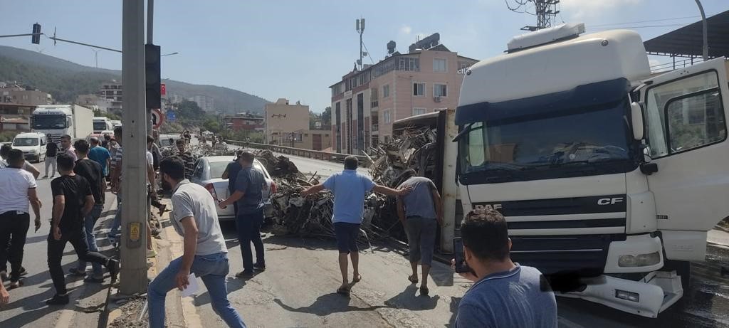 Hatay’da enkazdan çıkan demirleri taşıyan tırın devrildiği kazada, 4 araç zarar gördü.