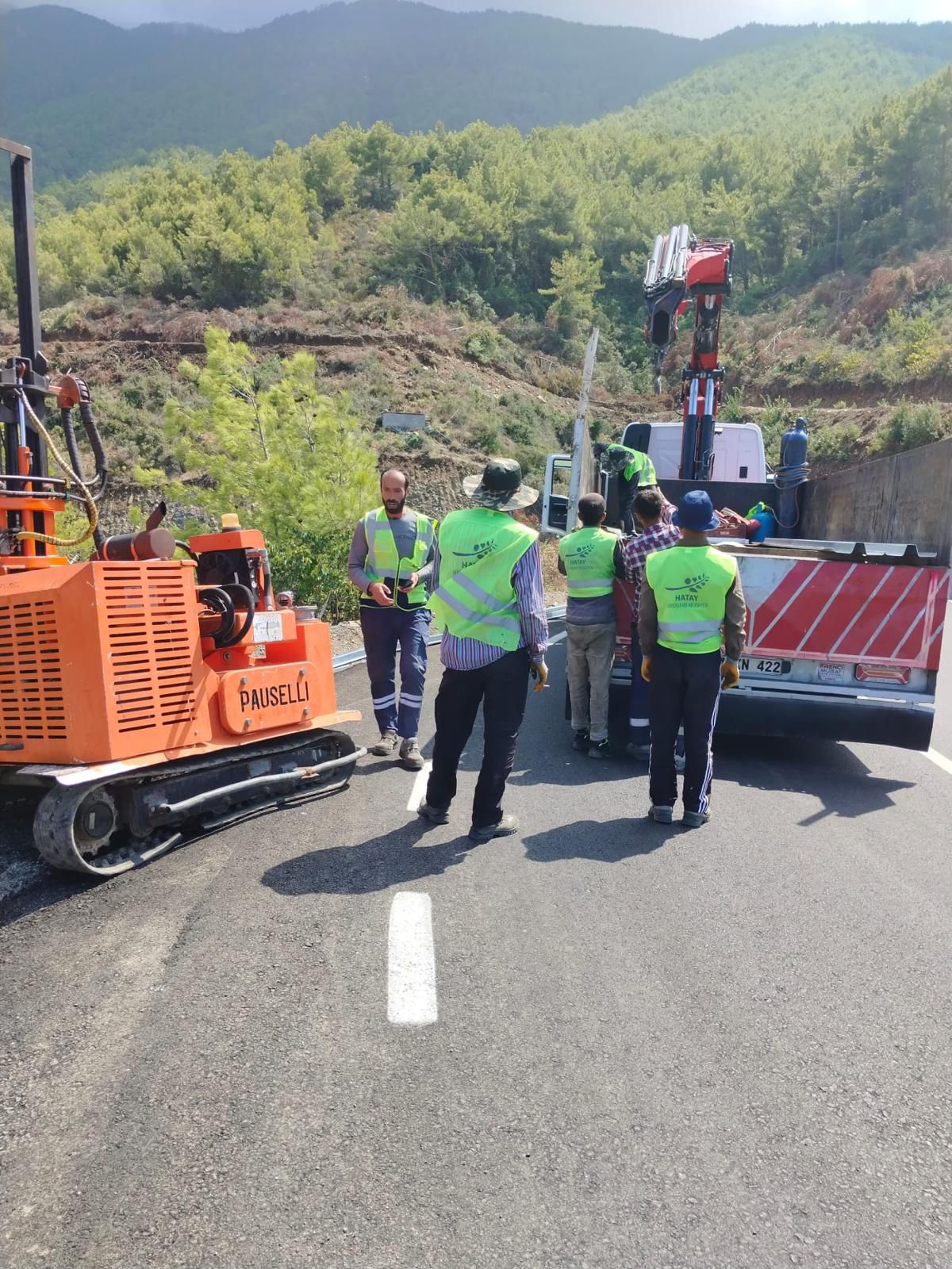 Hatay Büyükşehir Belediyesi, 15 ilçede yol yapım ve modernizasyon çalışmalarının yanı sıra, trafik güvenliğini artırmak için çelik otokorkuluk montajı gerçekleştiriyor.