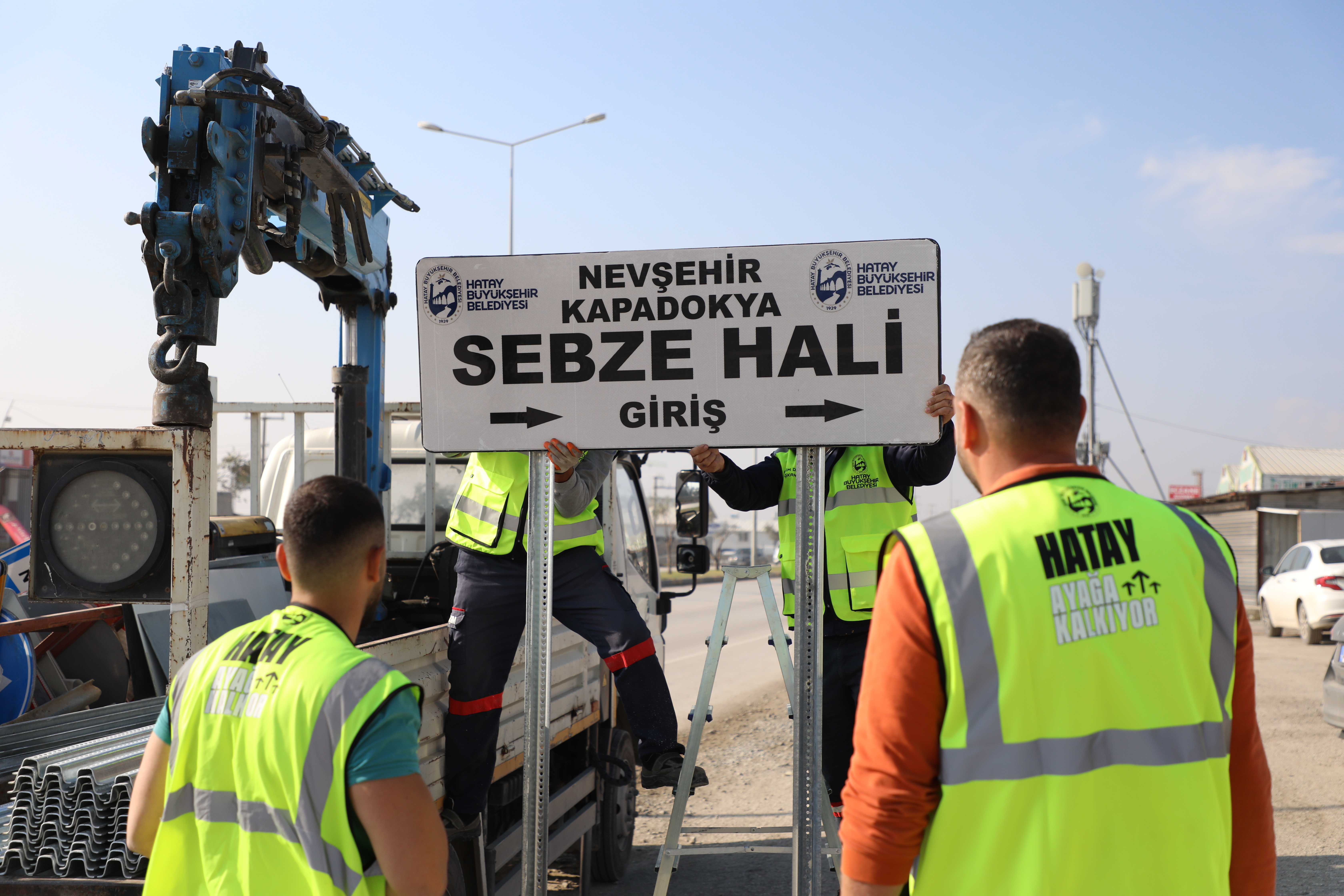 Hatay Büyükşehir Belediyesi, deprem sonrası şehirdeki adres belirsizliklerini gidermek ve güvenli ulaşımı sağlamak için fosforlu levhalar yerleştiriyor. Yeni levhalar gece görünürlüğü artırıyor.