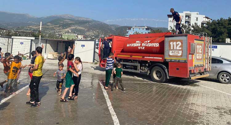 Hatay'ın Belen ilçesinde konteyner kentte yaşayan öğrenciler, sıcaktan bunalınca imdada itfaiye ekipleri yetişti.