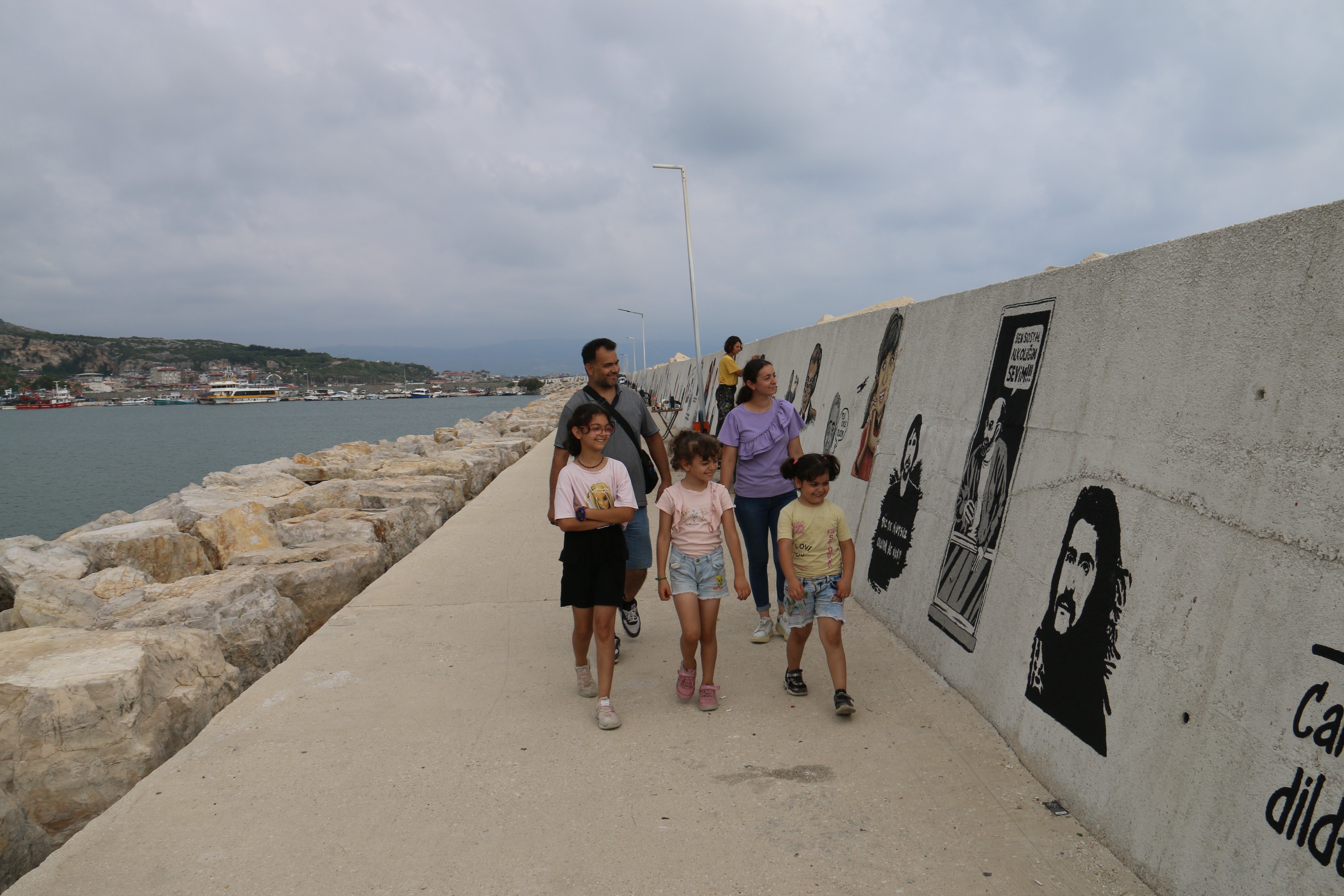 Samandağ'da depremin yaralarını sarmak için başlatılan projede, ressam Burcu Okar tarafından 9 ay boyunca 515 metrelik duvara 227 farklı resim çizildi.