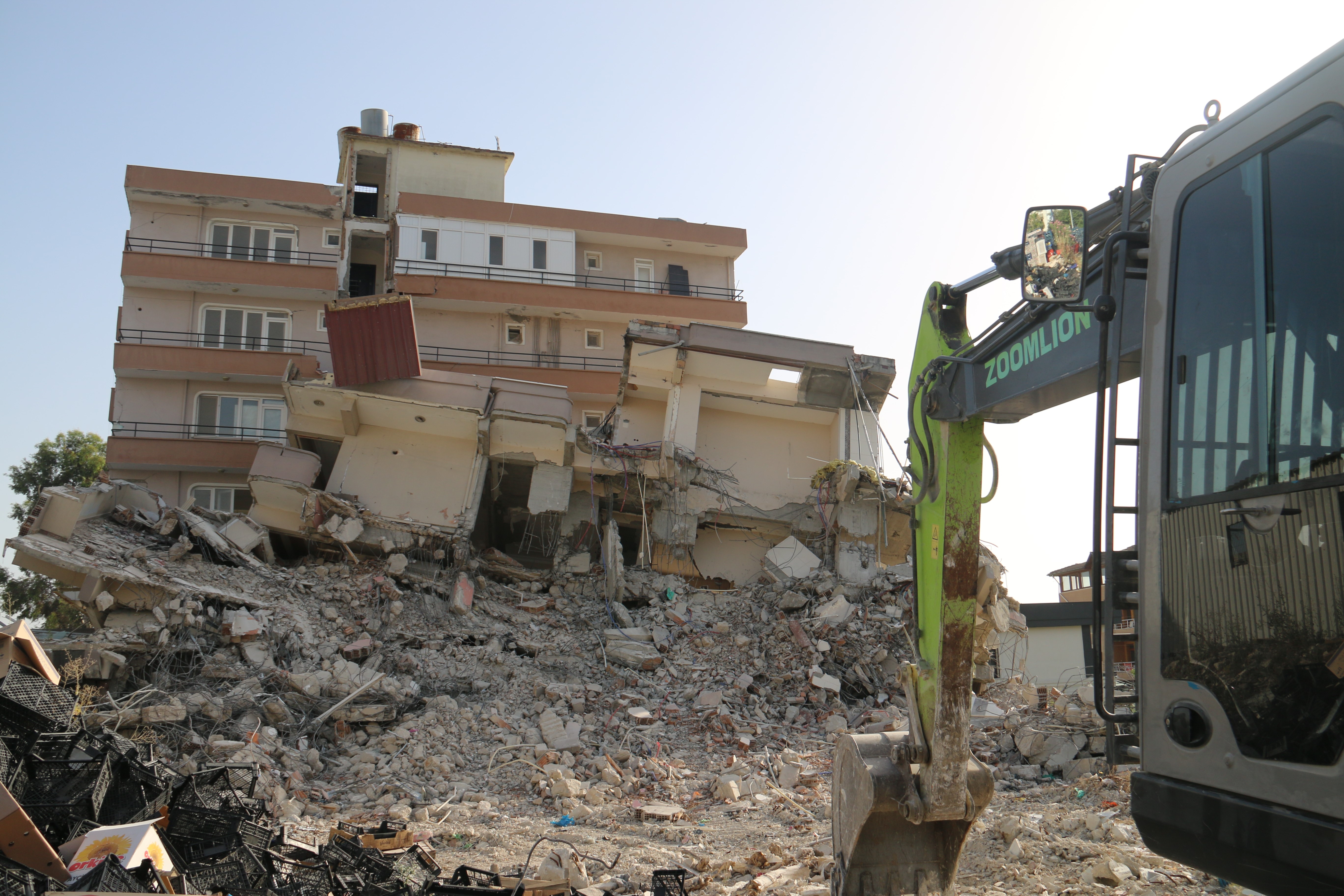 Hatay'ın Defne ilçesinde depremde az hasar gören 6 katlı bina, yıkım çalışmaları sırasında komşu binanın üzerine devrildi.