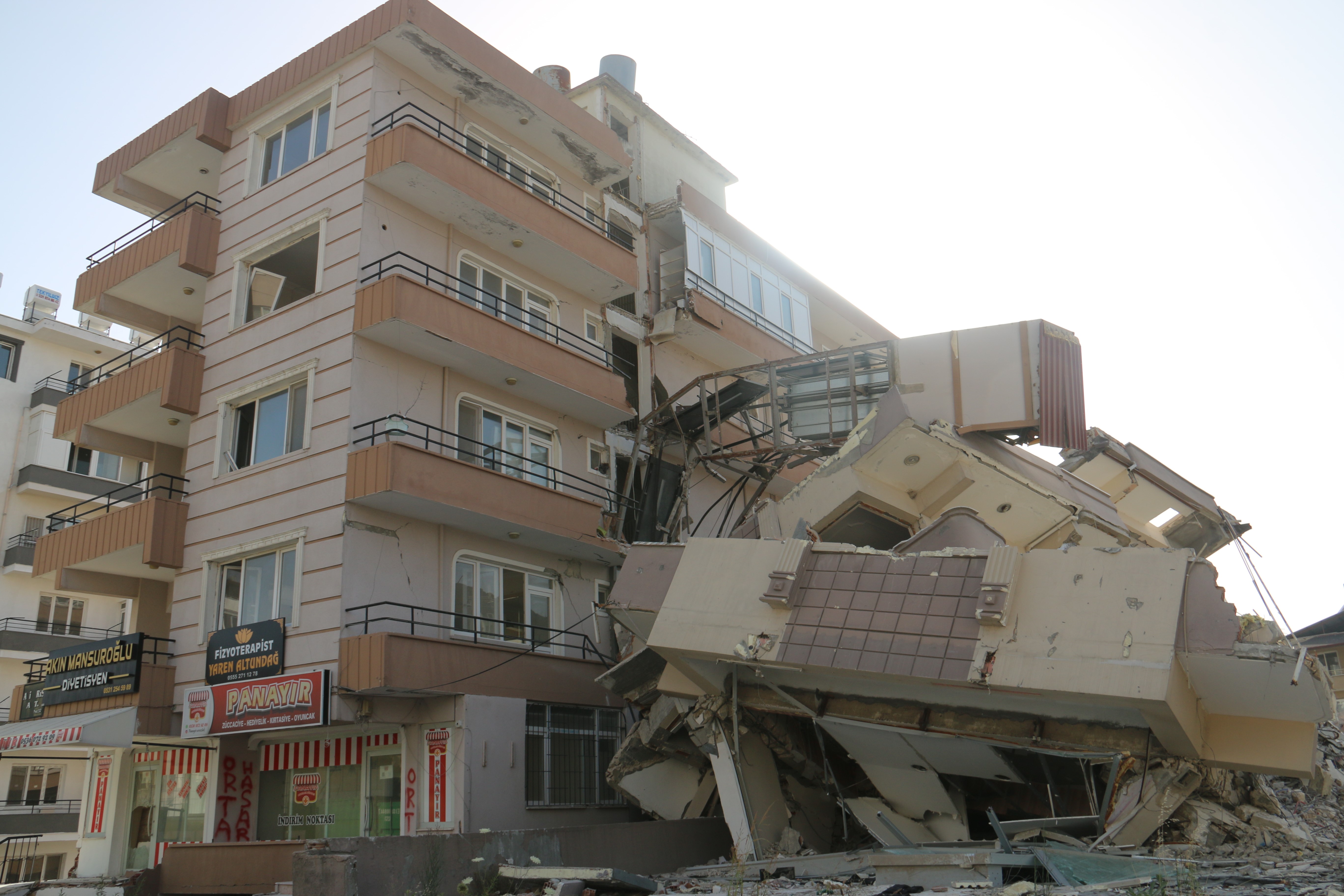 Hatay'ın Defne ilçesinde depremde az hasar gören 6 katlı bina, yıkım çalışmaları sırasında komşu binanın üzerine devrildi.