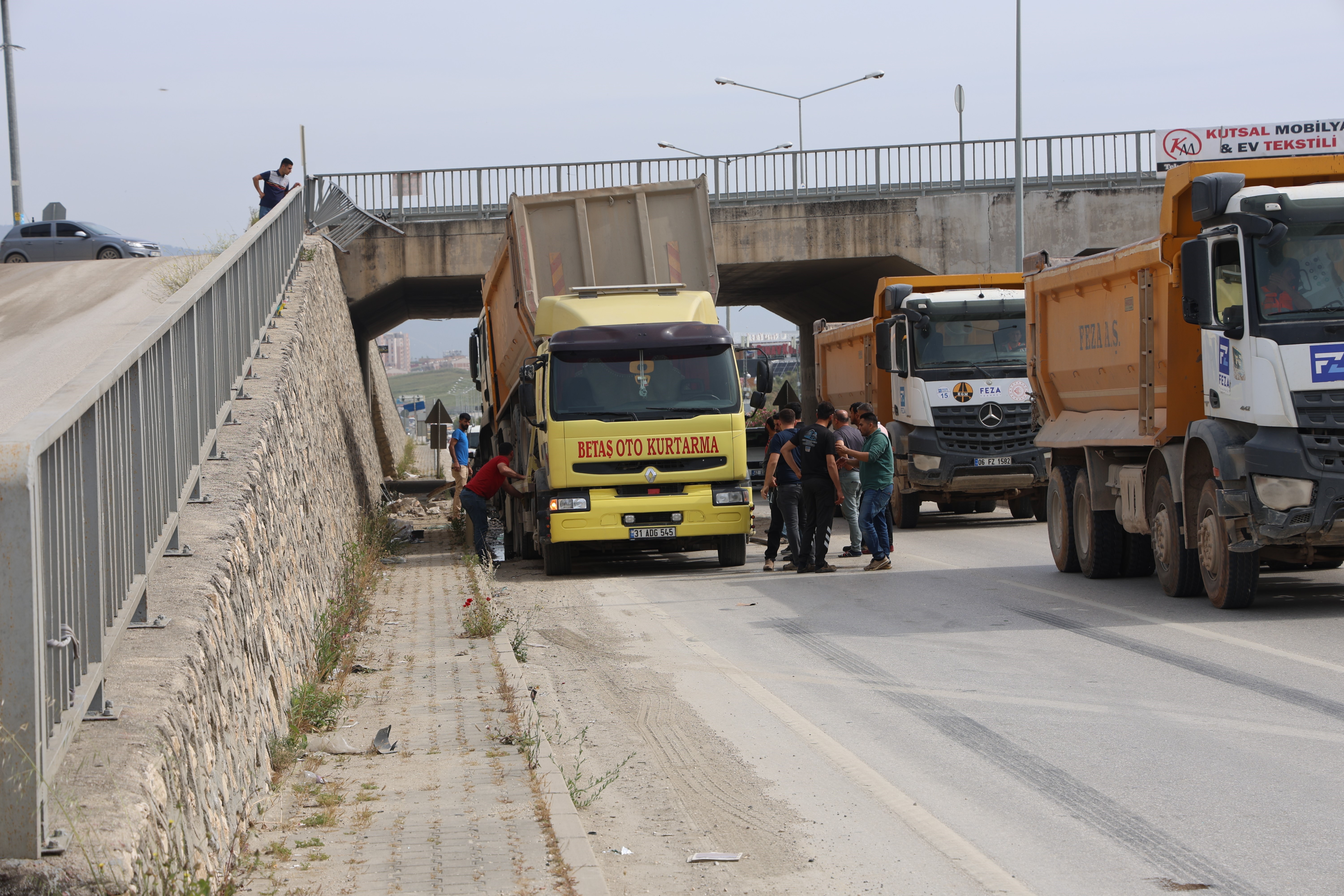 Hatay'ın Defne ilçesinde meydana gelen korkunç kazada, yola dökülen bir sıvı nedeniyle kontrolünü kaybeden hafriyat kamyonu, 5 metre yüksekliğindeki bir duvarı aşarak havada uçtu.